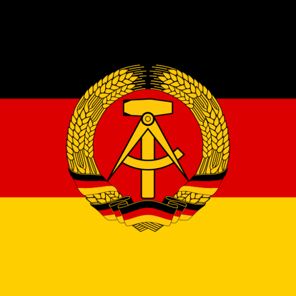 Die Staatsflagge der DDR. Schwarz, rot, gold mit Hammer und Zirkel im Ährenkranz.
